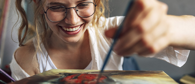 mulher feliz pintando um quadro