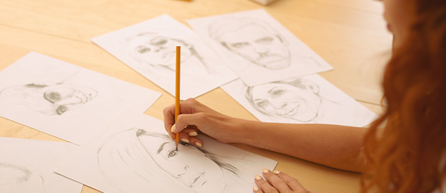 garota fazendo esboços de desenhos com papel e lápis