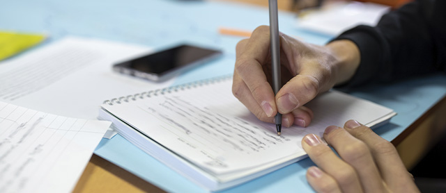 pessoa praticando escrita criativa em um caderno sobre a mesa
