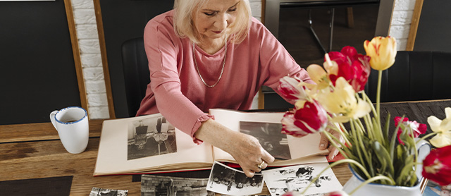 mulher idosa fazendo colagem com suas fotos antigas