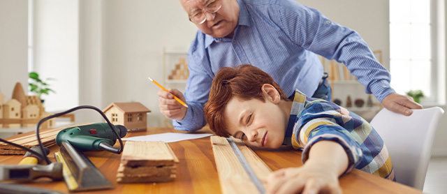 senhor idoso e seu neto fazendo peças de madeira como uma prática de artesanato terapêutico