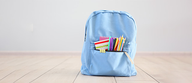 mochila escolar organizada com vários materiais no bolso da frente