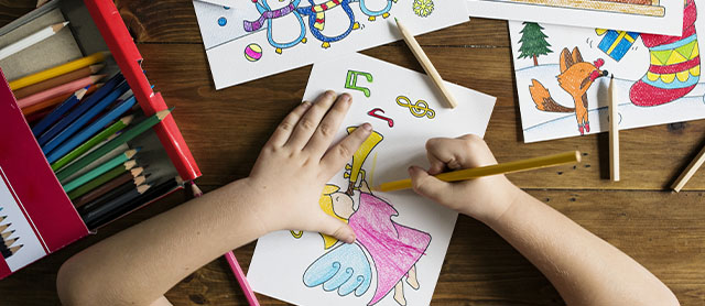 criança usando materiais escolares para fazer desenhos que estimulam sua criatividade