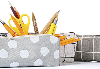 três estojos escolares com materiais saindo pelo zíper