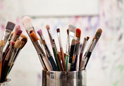 vários tipos de pincéis em uma lata em um ateliê de pintura