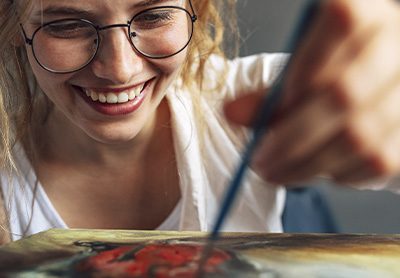 mulher feliz pintando um quadro