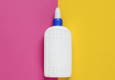tubo de cola escolar sobre um fundo rosa e amarelo