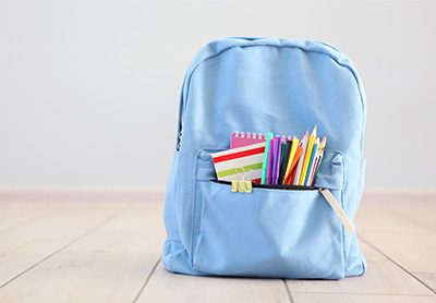 mochila escolar organizada com vários materiais no bolso da frente